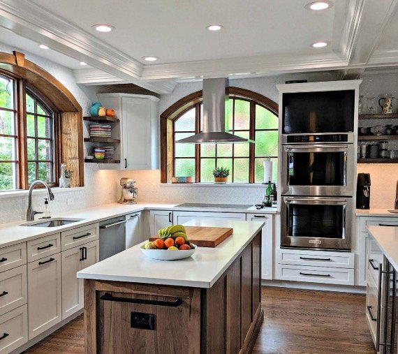 Bright remodeled kitchen with island, arched windows, and white cabinetry