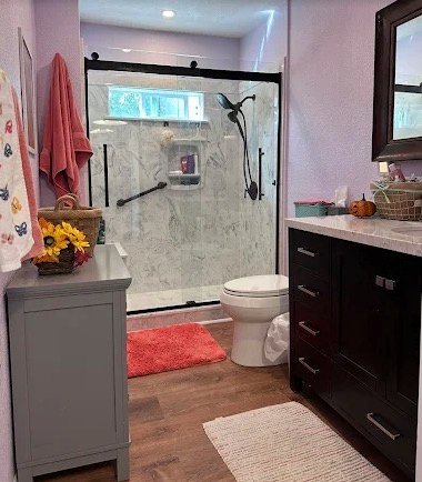Bathroom remodel with glass shower door, vanity, and warm flooring