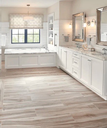 Bright bathroom remodel with double vanity, soaking tub, and wood-look floors