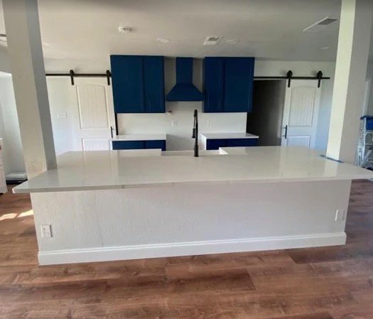 Kitchen remodel with blue cabinets, white counters, and barn doors