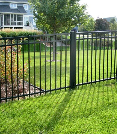 Black metal yard fence around a lawn