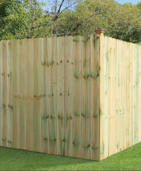Treated wood privacy fence corner in a backyard